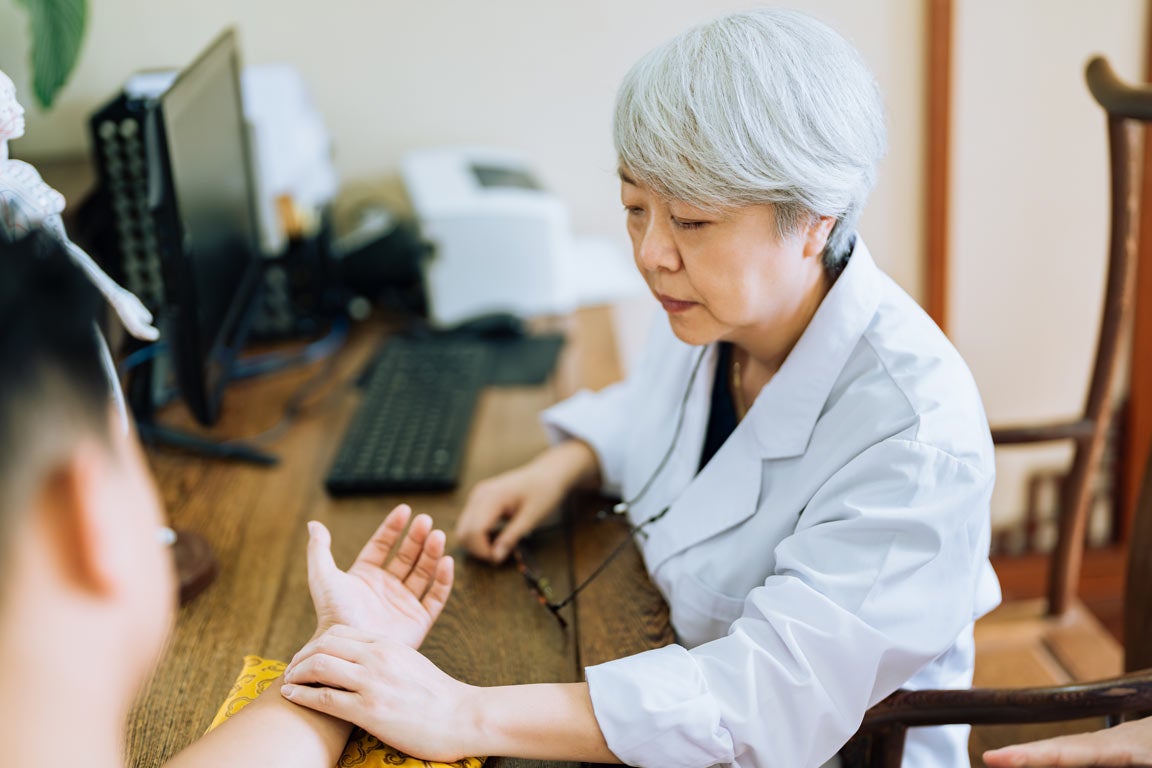 A traditional Chinese medicine doctor checks a patient's pulse