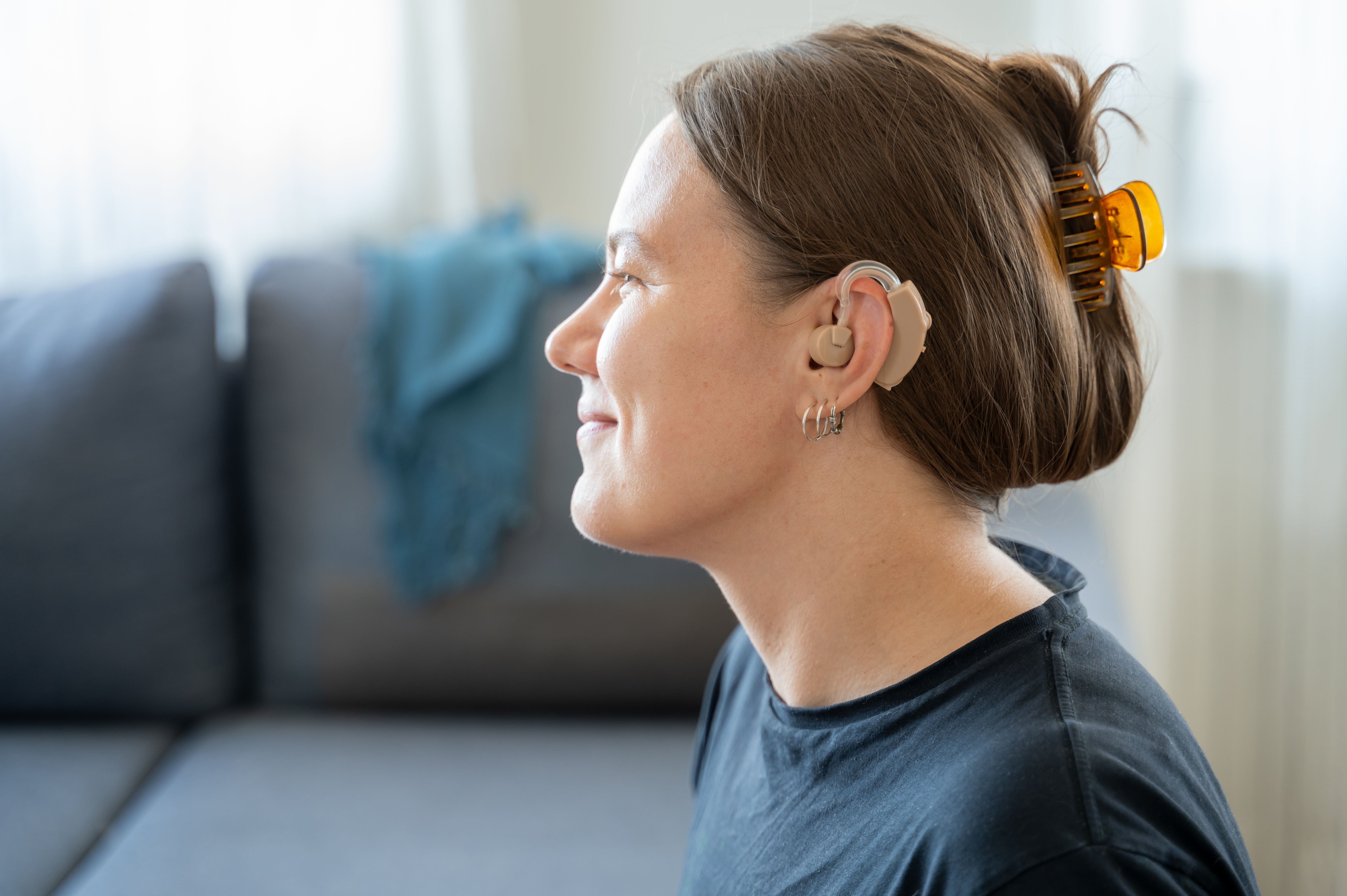 Side profile of woman with hearing aid in ear