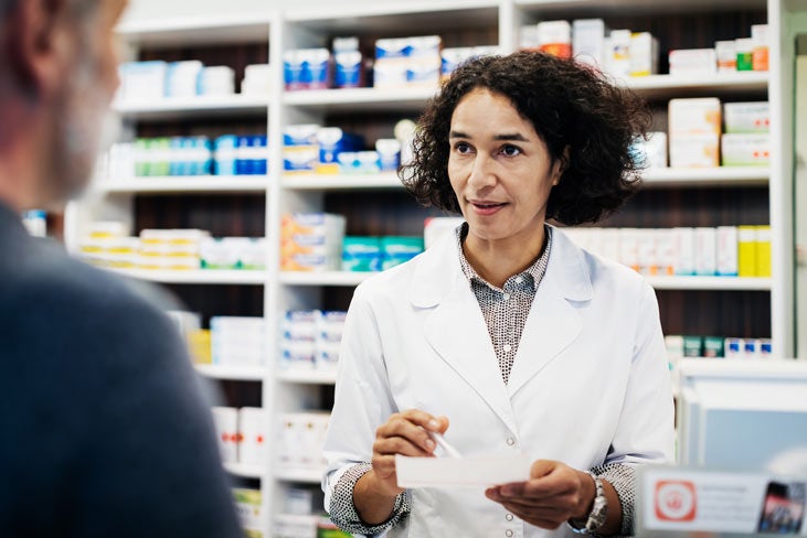 Female pharmacist speaking with patient about medications