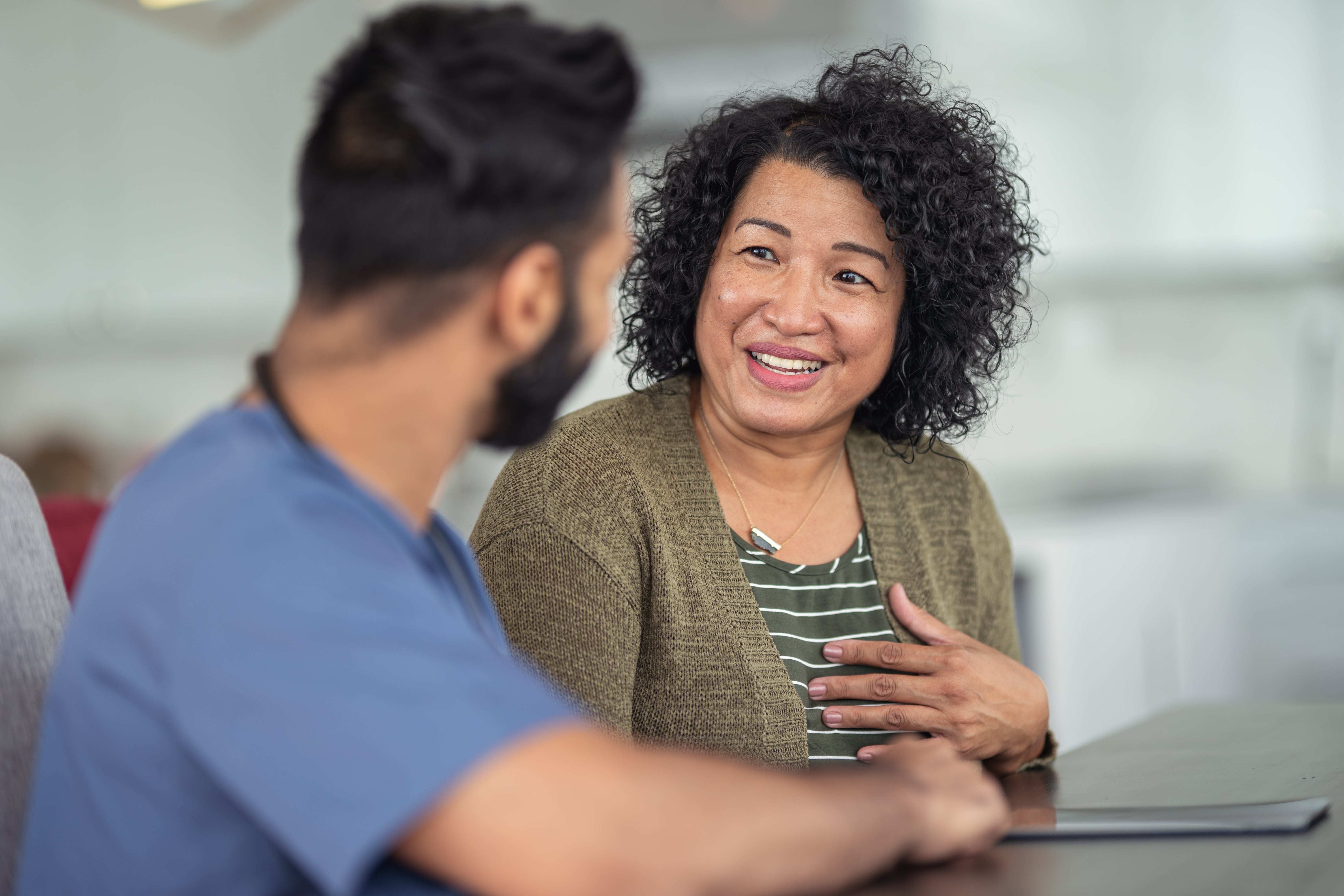A woman smiles as she talks with her doctor