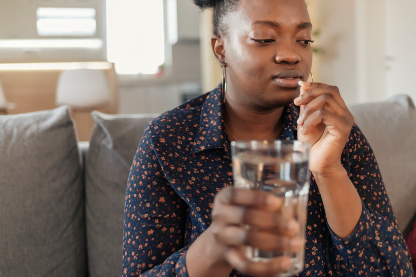 African American woman taking medicine