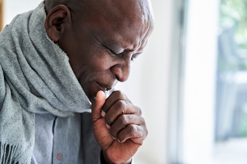 Senior African-American man coughing in his hand 