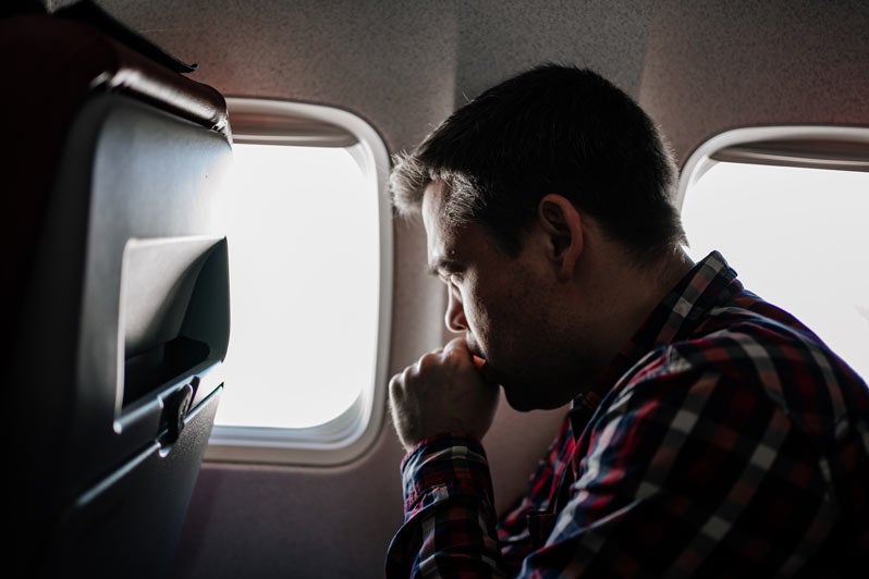 Man coughs on the plane in a window seat