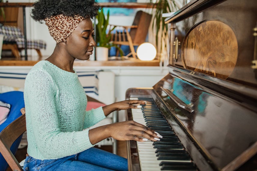 A woman plays a piano