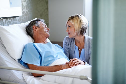 Woman talking with husband in hospital room