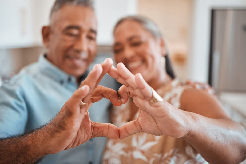 Mature couple making a heart with their hands