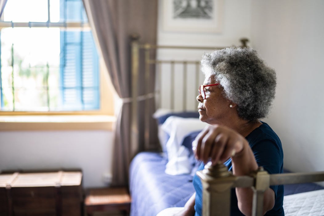 Senior woman sitting in bedroom