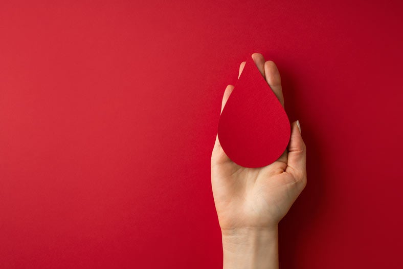 Hand holding paper red drop